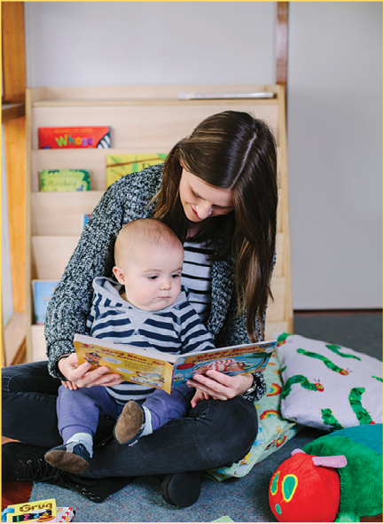 Carer and baby reading together with enjoyment